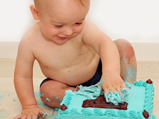 Baby playing with its cake